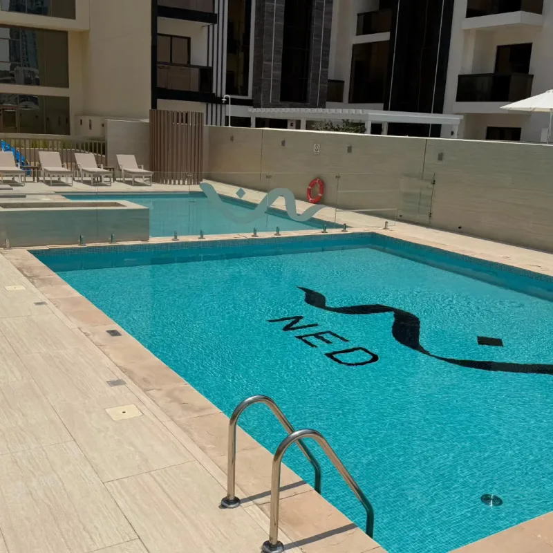 A residential building pool with a dark mosaic motif set into the floor