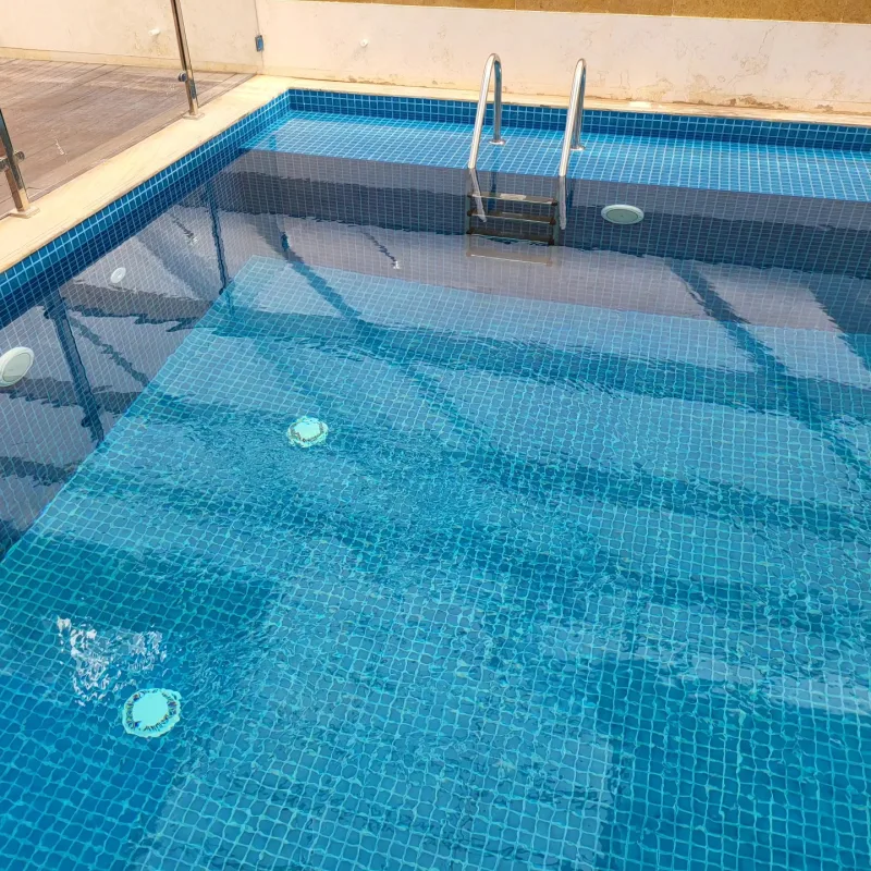 مسبح مجتمعي مبلّط بفسيفساء زرقاء بإطار رخامي