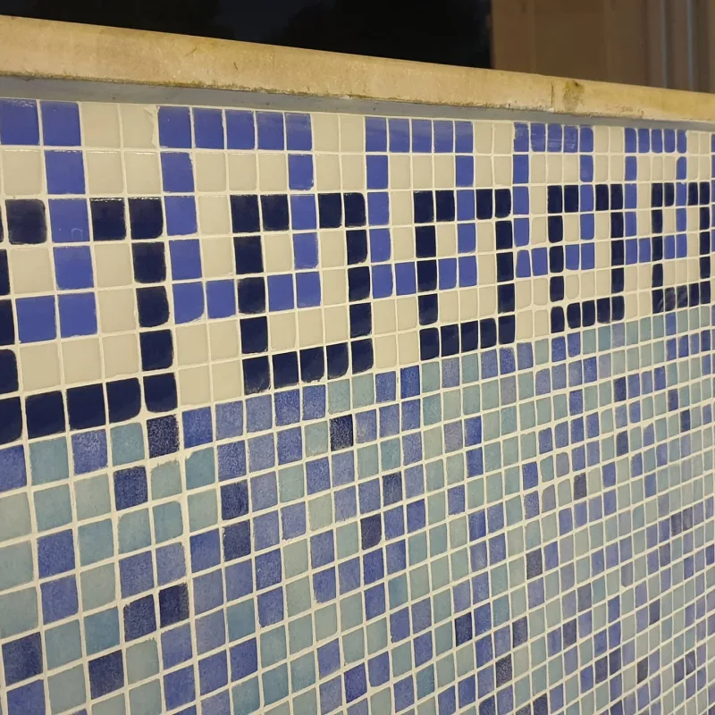 Glass mosaic tiling and a patterned border on a pool wall