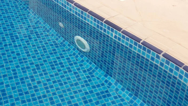 Glass mosaic tiling and a patterned border on a pool wall